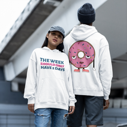 Two people wearing white hoodies with humorous text and graphics outdoors.