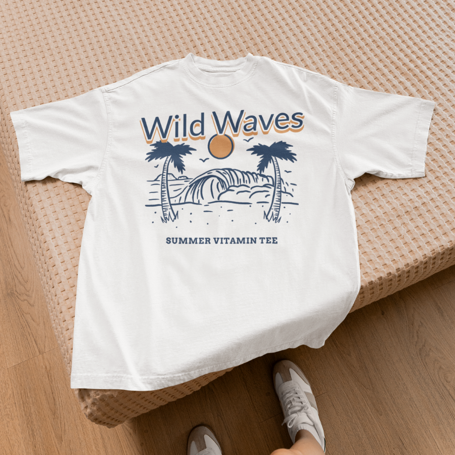 Ảnh áo thun trắng in hình sóng biển, cây dừa và mặt trời cam, dòng chữ "Wild Waves – Summer Vitamin Tee", phong cách tối giản mang vibe mùa hè.