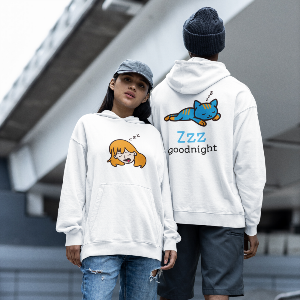 Two people wearing white hoodies with cartoon designs on a city street.