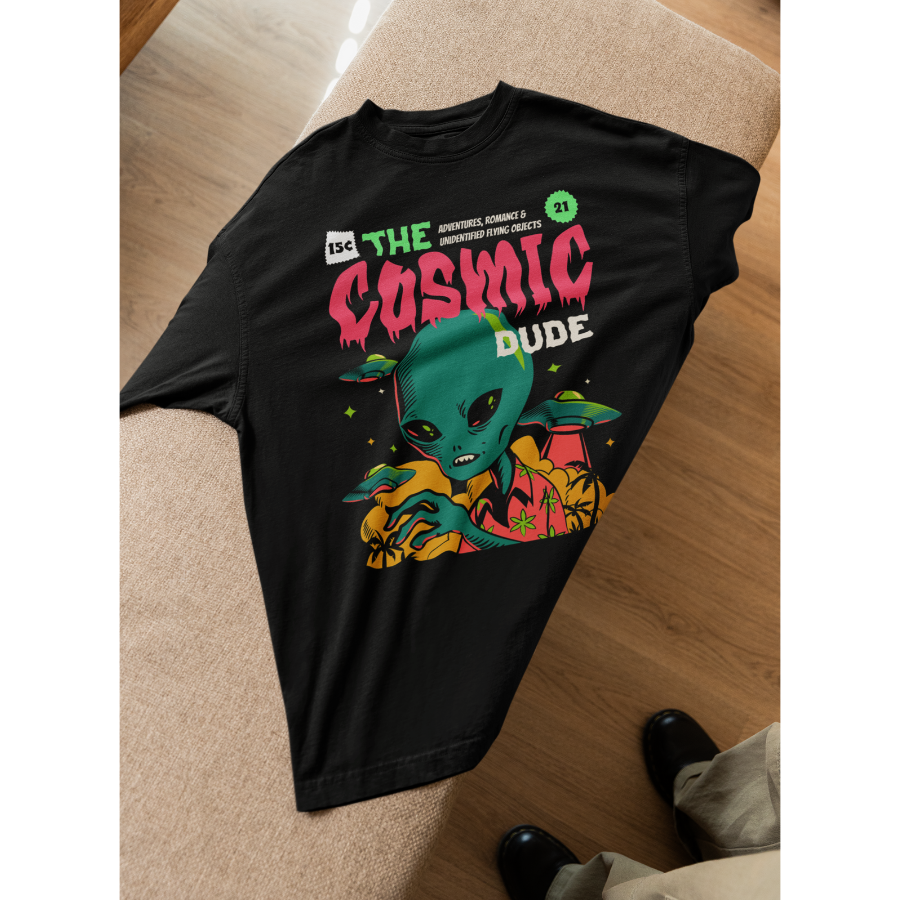 Áo thun unisex in hình người ngoài hành tinh, UFO, nấm và chữ “The Cosmic Dude” màu neon rực rỡ. Thiết kế đậm chất truyện tranh viễn tưởng – streetwear nổi bật.