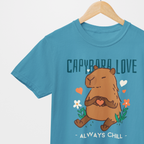 Áo thun xanh in hình capybara cầm trái tim, bao quanh là hoa lá và slogan “Always Chill”, có thể tuỳ chỉnh dòng chữ phía trên