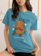 Áo thun xanh in hình capybara cầm trái tim, bao quanh là hoa lá và slogan “Always Chill”, có thể tuỳ chỉnh dòng chữ phía trên