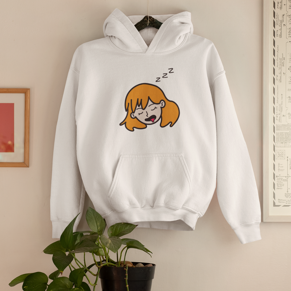 White hoodie with cartoon design of a sleeping girl on a beige wall.