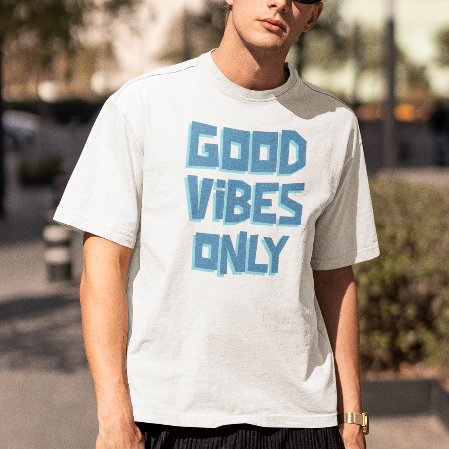 Áo thun trắng in chữ “GOOD VIBES ONLY” font 3D màu xanh, mẫu thứ hai in “YOUR SLOGAN HERE” để cá nhân hóa theo yêu cầu